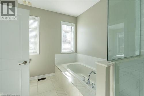 Bathroom featuring tile patterned flooring, a healthy amount of sunlight, and separate shower and tub - 219 Falconridge Drive, Waterloo, ON - Indoor Photo Showing Bathroom