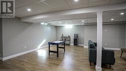 Recreation room with hardwood / wood-style flooring and a paneled ceiling - 