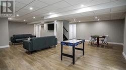 Living room featuring a paneled ceiling and wood-type flooring - 