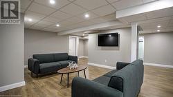 Living room with a paneled ceiling and wood-type flooring - 