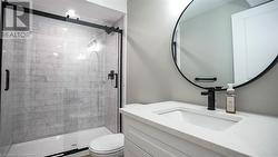 Bathroom with a shower with shower door, vanity, and toilet - 