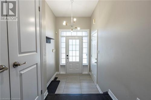 Doorway to outside featuring an inviting chandelier and tile patterned flooring - 219 Falconridge Drive, Waterloo, ON - Indoor Photo Showing Other Room