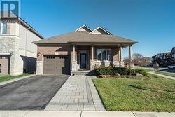 View of front of home with a garage, covered porch, and a front lawn - 