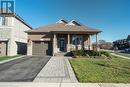 View of front of home with a garage, covered porch, and a front lawn - 219 Falconridge Drive, Kitchener, ON  - Outdoor With Facade 