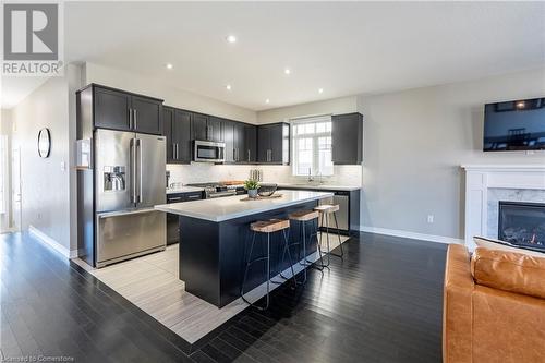 Kitchen featuring stainless steel appliances, a kitchen island, sink, hardwood / wood-style flooring, and a breakfast bar area - 219 Falconridge Drive, Kitchener, ON - Indoor Photo Showing Kitchen With Stainless Steel Kitchen With Upgraded Kitchen