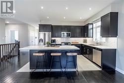 Kitchen featuring light wood-type flooring, stainless steel appliances, sink, and a center island - 