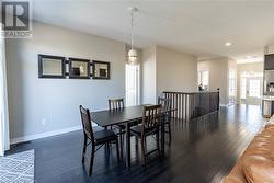 Dining area with dark hardwood / wood-style flooring and a notable chandelier - 