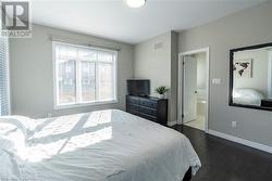 Bedroom with ensuite bath and dark wood-type flooring - 