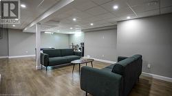 Living room featuring a drop ceiling and hardwood / wood-style flooring - 