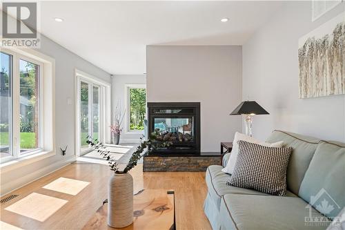 Large family room features surround sound and 3-way gas fireplace with remote. - 10 Riverbrook Road, Ottawa, ON - Indoor Photo Showing Living Room With Fireplace