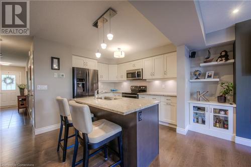 Kitchen island with seating, sink, electrical outlet and dishwasher. Upgraded light fixtures. - 625 Blackbridge Road Unit# 12, Cambridge, ON - Indoor Photo Showing Kitchen