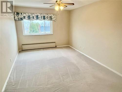 Unfurnished room featuring a baseboard radiator, ceiling fan, and light carpet - 810 Main Street W Unit# 302, North Bay, ON - Indoor Photo Showing Other Room