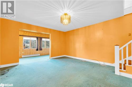 Spare room featuring a notable chandelier, carpet floors, and a baseboard heating unit - 14686 County Road 509, Mississippi Station, ON - Indoor Photo Showing Other Room