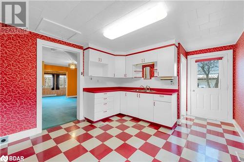 Kitchen featuring a wealth of natural light, sink, light colored carpet, and a baseboard heating unit - 14686 County Road 509, Mississippi Station, ON - Indoor