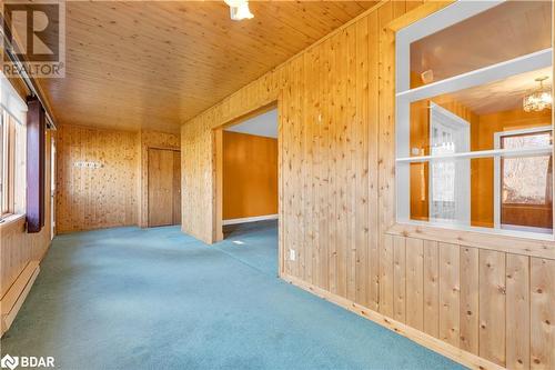 Carpeted empty room featuring wooden walls, a healthy amount of sunlight, and wooden ceiling - 14686 County Road 509, Mississippi Station, ON - Indoor Photo Showing Other Room