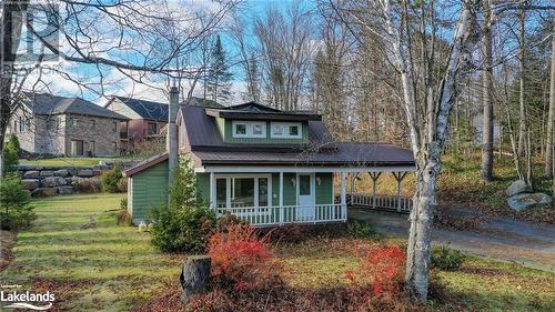 View of front of home with covered porch and a front lawn - 646 Muskoka 3 Road N, Huntsville, ON 