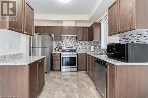 Kitchen featuring decorative backsplash, appliances with stainless steel finishes, light stone countertops, and sink - 40 Todd Crescent, Dundalk, ON - Indoor Photo Showing Kitchen With Stainless Steel Kitchen With Double Sink With Upgraded Kitchen