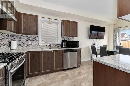 Kitchen featuring tasteful backsplash, dark brown cabinetry, stainless steel appliances, sink, and exhaust hood - 40 Todd Crescent, Dundalk, ON - Indoor Photo Showing Kitchen With Stainless Steel Kitchen With Double Sink