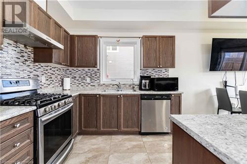 Kitchen with sink, tasteful backsplash, range hood, appliances with stainless steel finishes, and light stone counters - 40 Todd Crescent, Dundalk, ON - Indoor Photo Showing Kitchen With Stainless Steel Kitchen With Double Sink With Upgraded Kitchen