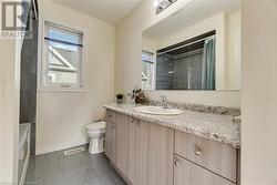 Full bathroom featuring tile patterned floors, vanity, toilet, and shower / bathtub combination with curtain - 