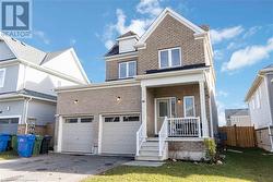 View of front of property with a garage, covered porch, and a front yard - 