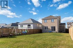 Rear view of property featuring a playground and a lawn - 