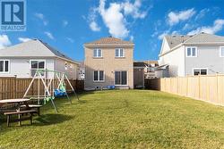 Rear view of house with a playground and a lawn - 