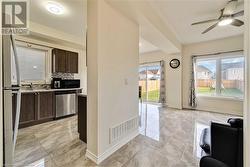 Kitchen with stainless steel dishwasher, plenty of natural light, dark brown cabinetry, and sink - 