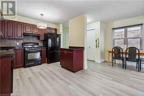 Kitchen with light hardwood / wood-style flooring, black appliances, decorative light fixtures, and backsplash - 42 Donnenwerth Drive, Kitchener, ON - Indoor Photo Showing Kitchen