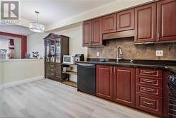 Kitchen with dishwasher, sink, stove, and light hardwood / wood-style flooring - 