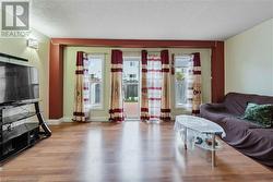 Living room with a textured ceiling and light hardwood / wood-style floors - 