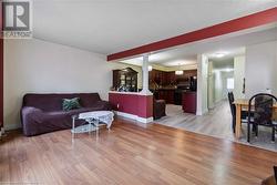 Living room with light hardwood / wood-style flooring and decorative columns - 