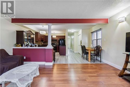 Living room featuring a textured ceiling, light wood-type flooring, sink, and decorative columns - 42 Donnenwerth Drive, Kitchener, ON - Indoor