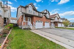 View of front of property with central AC unit, a garage, and a front yard - 