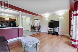 Living room with light wood-type flooring and ornate columns - 