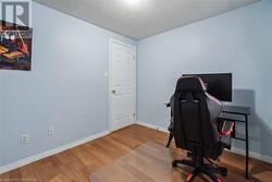 Office area with hardwood / wood-style flooring and a textured ceiling - 