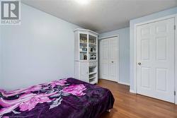 Bedroom featuring hardwood / wood-style floors, a textured ceiling, and a closet - 