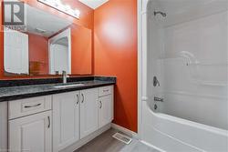 Bathroom featuring hardwood / wood-style floors, vanity, and tub / shower combination - 