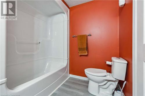 Bathroom with toilet, a textured ceiling, hardwood / wood-style flooring, and walk in shower - 42 Donnenwerth Drive, Kitchener, ON - Indoor Photo Showing Bathroom