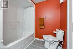 Bathroom with toilet, a textured ceiling, hardwood / wood-style flooring, and walk in shower - 