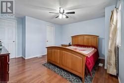 Bedroom with dark wood-type flooring, ceiling fan, and a textured ceiling - 