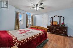 Bedroom featuring light wood-type flooring, a textured ceiling, and ceiling fan - 