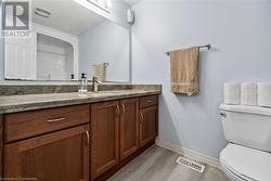 Bathroom featuring toilet, vanity, and wood-type flooring - 