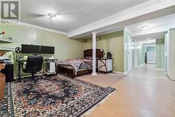 Bedroom with hardwood / wood-style flooring, crown molding, and white refrigerator - 