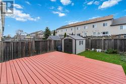 Wooden terrace featuring a lawn and a storage shed - 