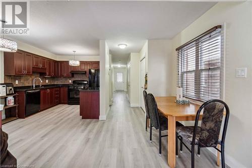 Kitchen with decorative backsplash, black appliances, sink, light wood-type flooring, and decorative light fixtures - 42 Donnenwerth Drive, Kitchener, ON - Indoor