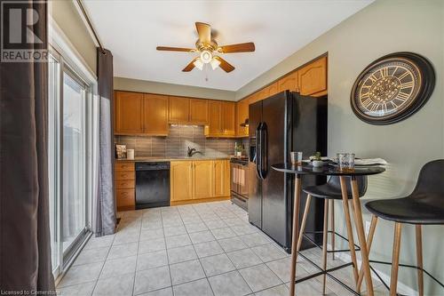 Kitchen featuring decorative backsplash, ceiling fan, sink, black appliances, and light tile patterned floors - 24 Kenyon Crescent Unit# 45, Grimsby, ON - Indoor Photo Showing Kitchen