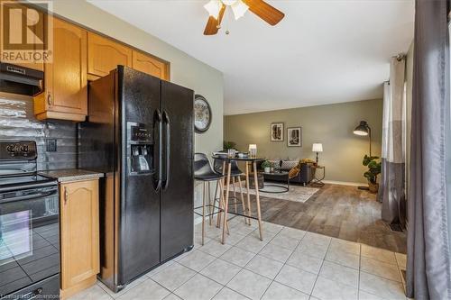 Kitchen featuring range hood, light hardwood / wood-style flooring, ceiling fan, and black appliances - 24 Kenyon Crescent Unit# 45, Grimsby, ON - Indoor Photo Showing Kitchen