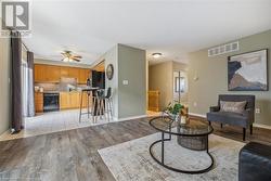 Living room featuring ceiling fan and light hardwood / wood-style floors - 