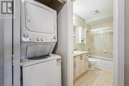 Washroom featuring sink, light tile patterned floors, and stacked washer / drying machine - 24 Kenyon Crescent Unit# 45, Grimsby, ON - Indoor Photo Showing Laundry Room